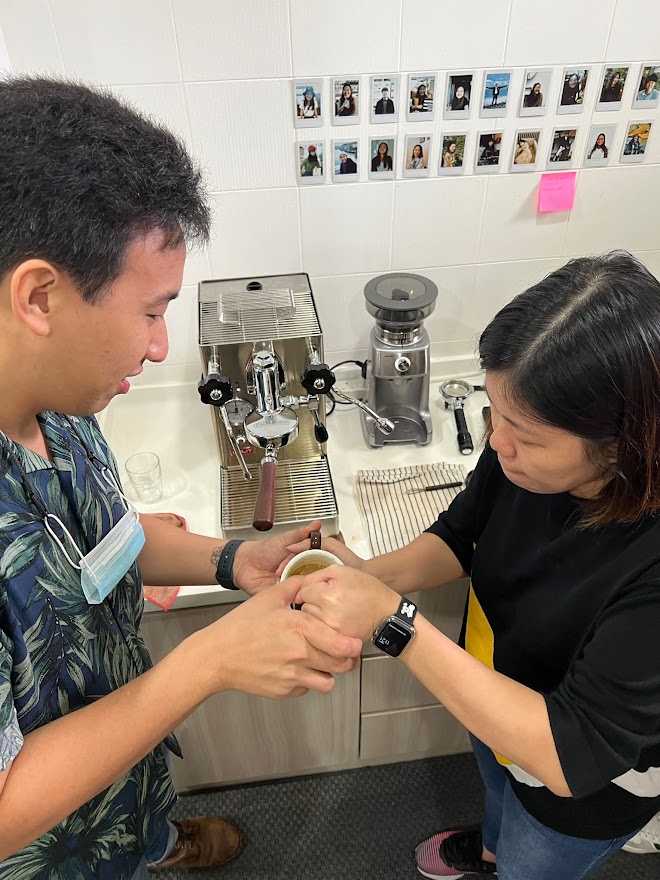 Instructor teaching student to pour latte art